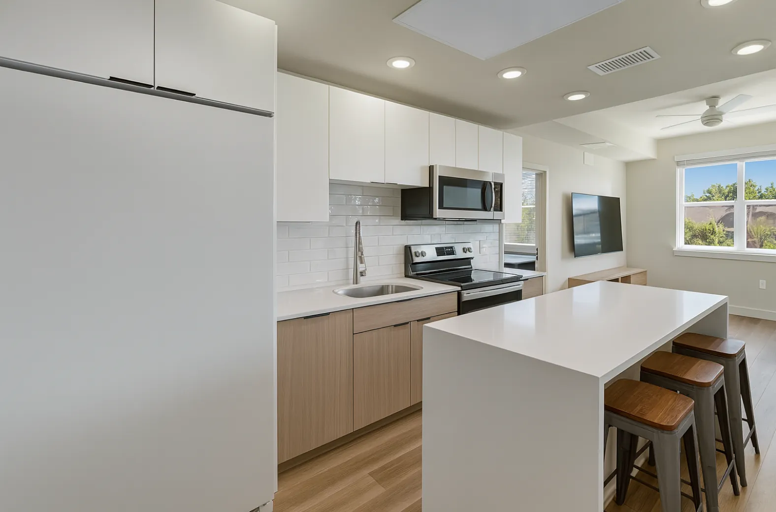 A Campus Gate kitchen with an island, stools and stainless appliances
