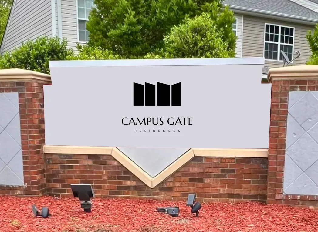 A brick monument sign with the Campus Gate logo in black