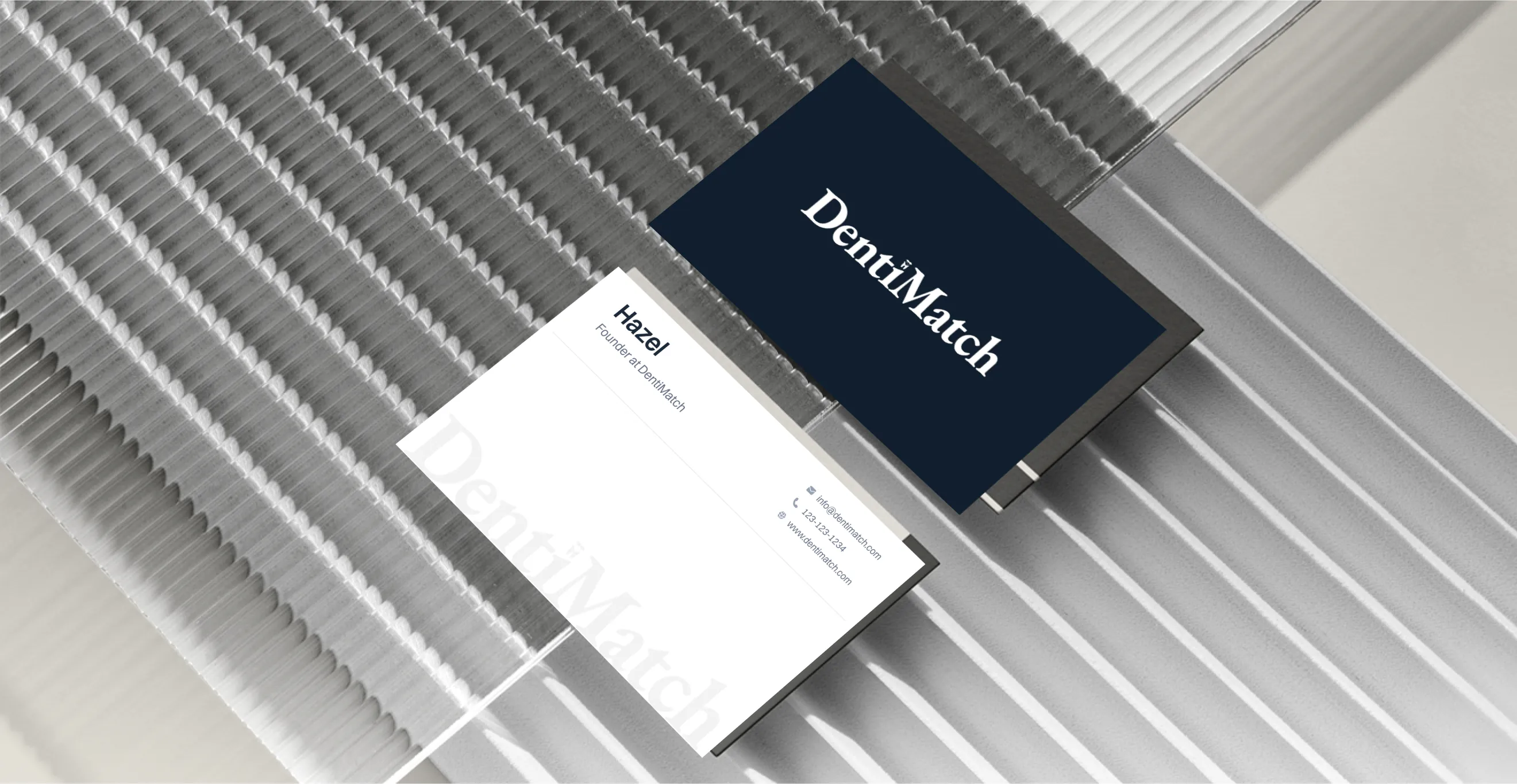 DentiMatch business cards, front and back, on a ribbed glass surface