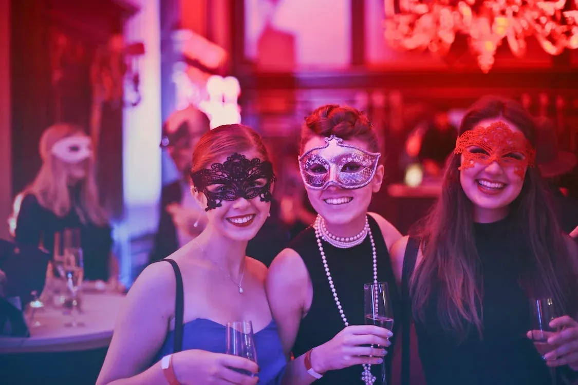 After: the new Eclectic Events homepage, showing a smiling guest in a red lace mask